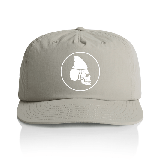 A grey quick dry baseball cap with a white circular graphic on the front featuring a stylized skull wearing a shark fin helmet, shown against a clean white background.